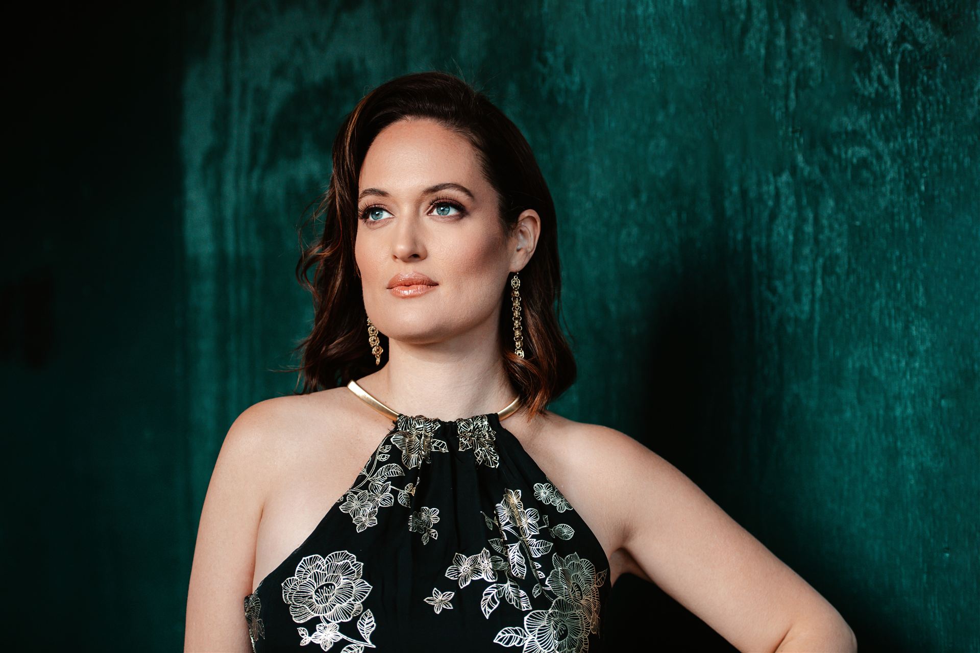 Chelsea Bonagura, coloratura soprano and voice technician, portrait against a green backdrop